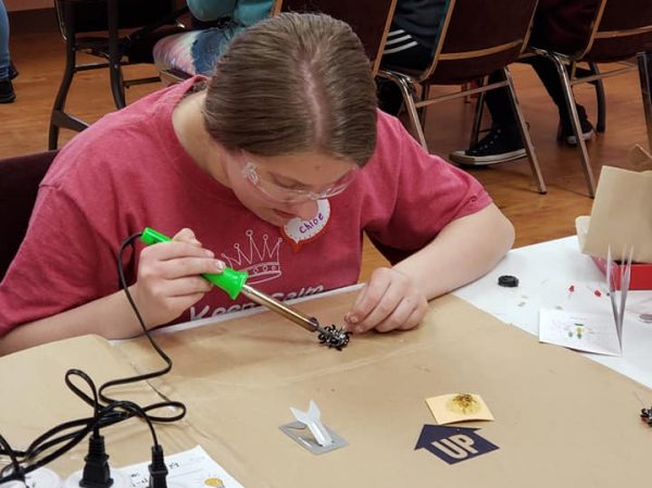 Girl Scout soldering for engineering badge