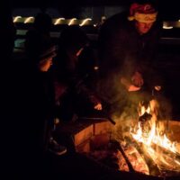 Cooking hotdogs at Winterfest over campfire