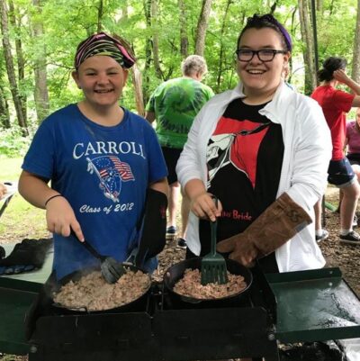 Girl Scouts cooking at a campout