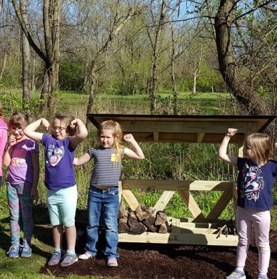 Daisy Scouts with their assembled fire wood shelter