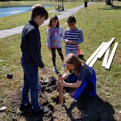 Daisy Scouts using post digger to dig hole for bat house pole