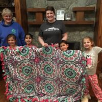 girls wit hno-sew fleece blanket to donate